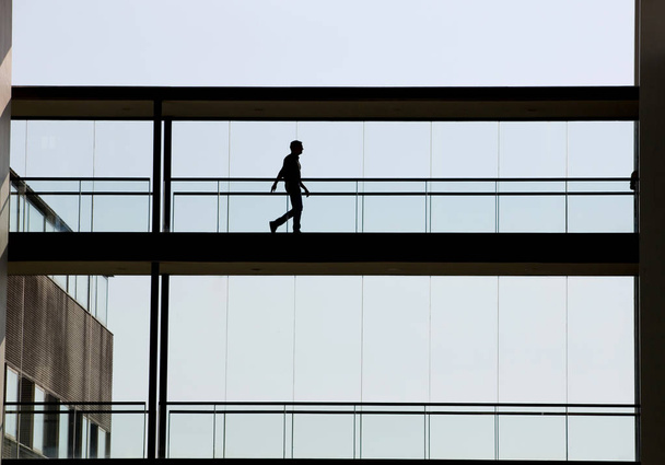 Vue silhouette de jeune homme d'affaires dans un immeuble de bureaux moderne intérieur
 - Photo, image