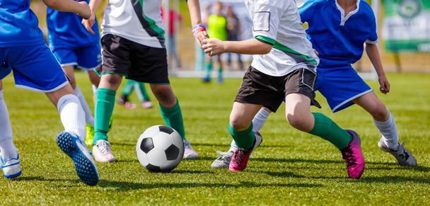 少年サッカー選手スポーツ分野のフットボールを蹴るします。青と白のジャージの選手を実行しています。サッカー水平背景 - 写真・画像
