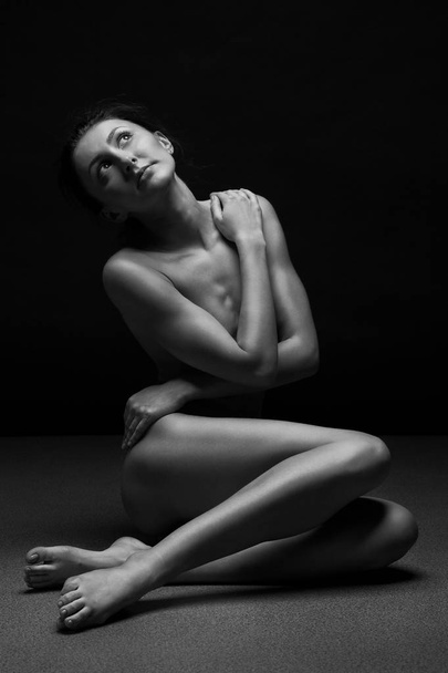 Beautiful body of young woman over dark background - Фото, зображення