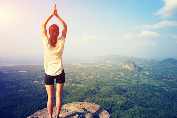 mujer practicando yoga en el pico de la montaña
 - Foto, Imagen