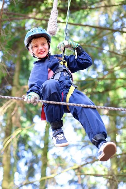 Happy boy climbing in outdoors adventure park - Foto, Imagen