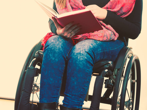 Young disabled woman in wheelchair with book. - Foto, imagen
