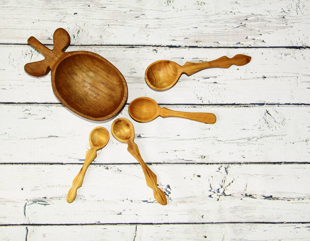 Dřevěné kuchyňské lžíce a talíř na stole, pohled shora - Fotografie, Obrázek