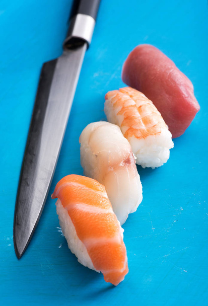 Four different nighiri sushi with a chefs knife - Photo, Image