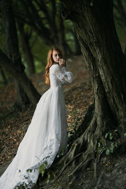 Young sexy redhead woman in white bridal vintage dress - Fotó, kép
