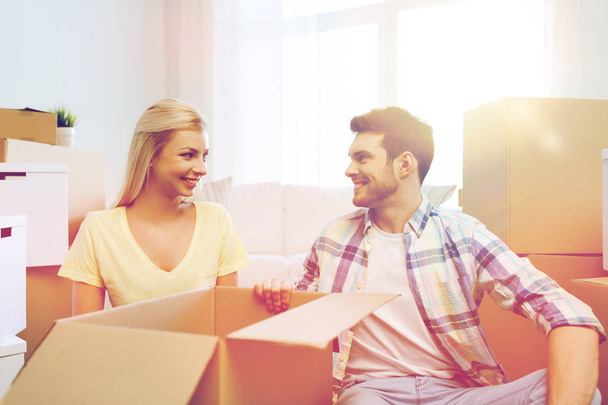 χαμογελώντας ζευγάρι με πολλά κουτιά που μετακινούνται σε νέο σπίτι - Φωτογραφία, εικόνα