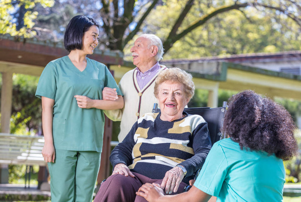 Szczęśliwy pielęgniarek i pacjentów w ogrodzie kliniki odwykowej - Zdjęcie, obraz