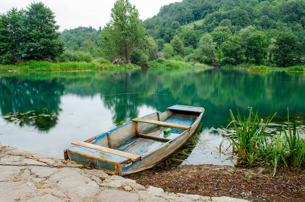 Дерев'яний човен на березі річки
 - Фото, зображення