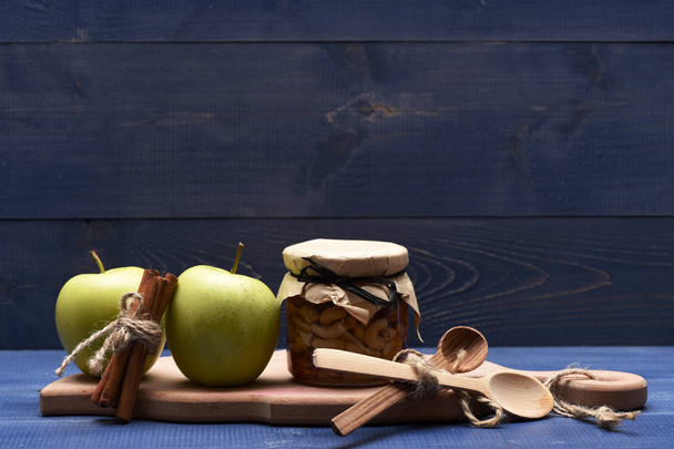 Apples, nuts in glass jar on cutting board - Valokuva, kuva