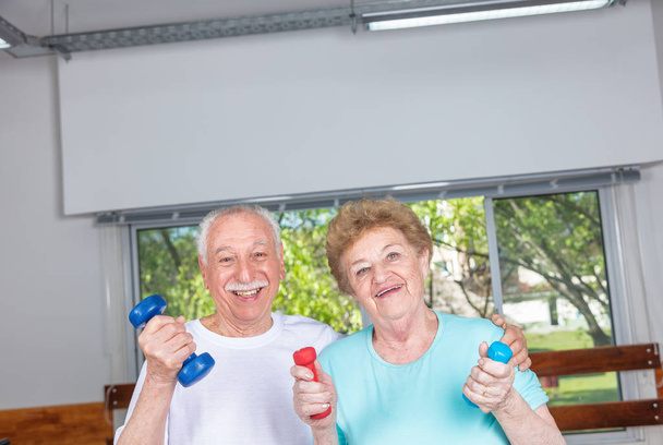 Starsza para wykonywanie ćwiczeń w siłowni - Zdjęcie, obraz