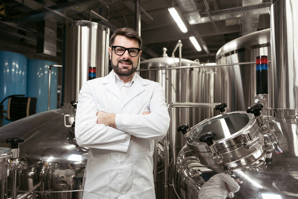 Overjoyed man standing at beer factory - Photo, image