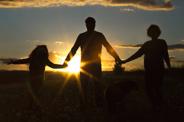 Familie auf einem Feld bei Sonnenuntergang - Foto, Bild