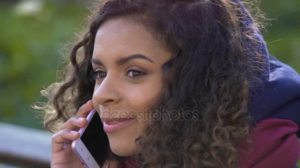 Young attractive female talking with her friend over mobile phone, closeup - Záběry, video