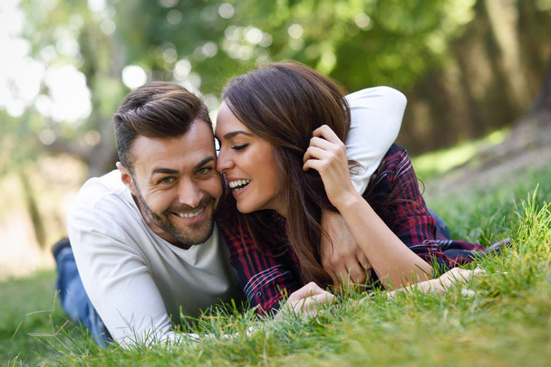 beau jeune couple posé sur l'herbe dans un parc urbain
.  - Photo, image