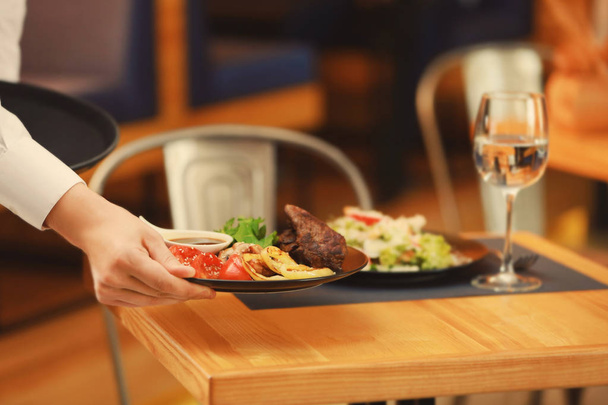 Waiter serving meals in restaurant - Foto, Bild