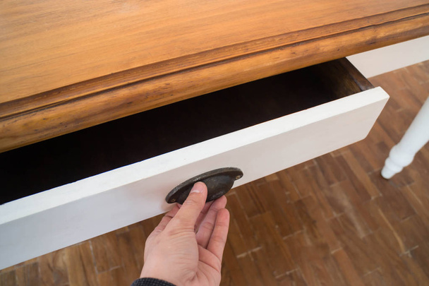 Hand geöffnete Schublade mit Holztisch - Foto, Bild