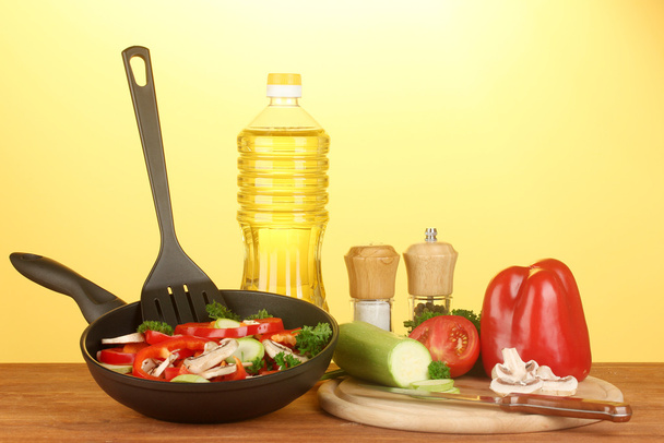 frying pan with vegetables on yellow background - Photo, Image
