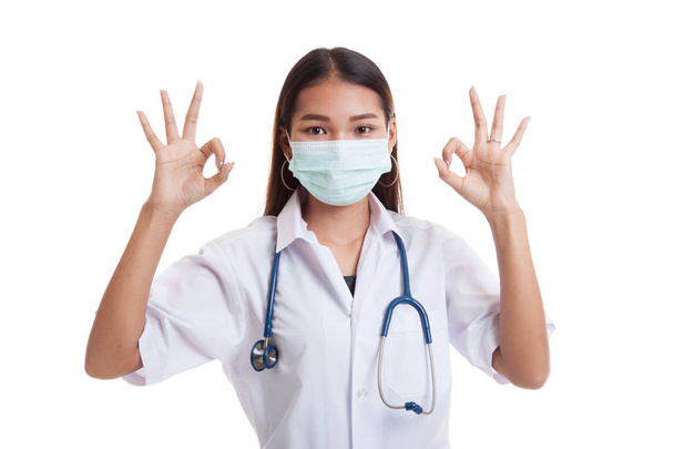 Young Asian female doctor with mask show OK with both hands. - Foto, imagen