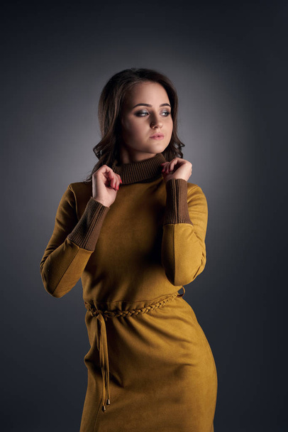 Young sexy girl posing in slinky mustard dress - Photo, Image
