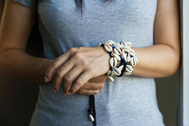 Porceláncsiga shell karkötők a nő csuklóját - Fotó, kép