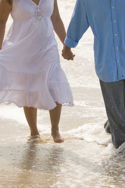 Couple holding hands walking on the beach. - Fotografie, Obrázek