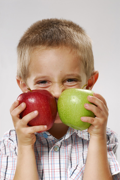 A little boy holding two apples. - Fotó, kép