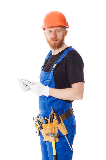 Man builder in the uniform with a tablet in the hands - Photo, image