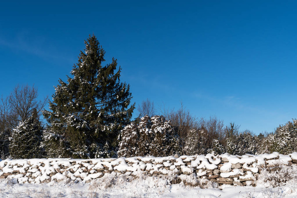 Śnieg pokryte kamienną ścianę i błękitne niebo - Zdjęcie, obraz