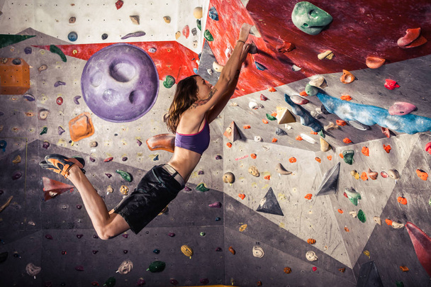 giovane donna arrampicata masso artificiale al chiuso
 - Foto, immagini