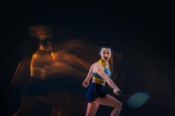 Portrait of beautiful girl tennis player with a racket on dark background - Foto, Bild