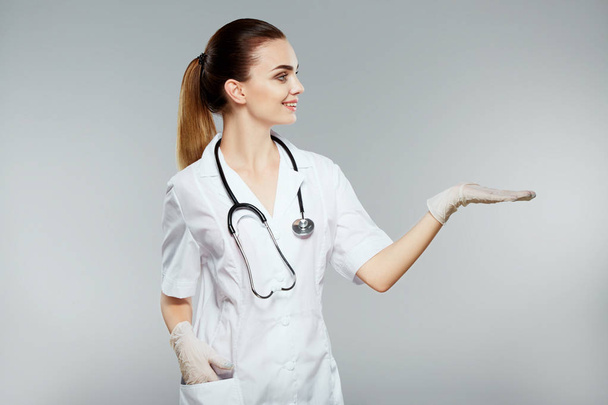 Medico femminile mostrando con mano
 - Foto, immagini