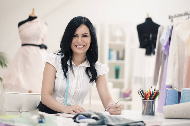 Smiling Fashion Designer at Her Desk - Photo, image