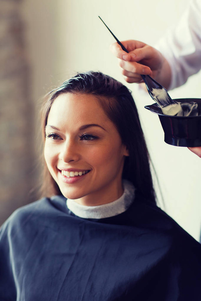 happy woman with stylist coloring hair at salon - Valokuva, kuva