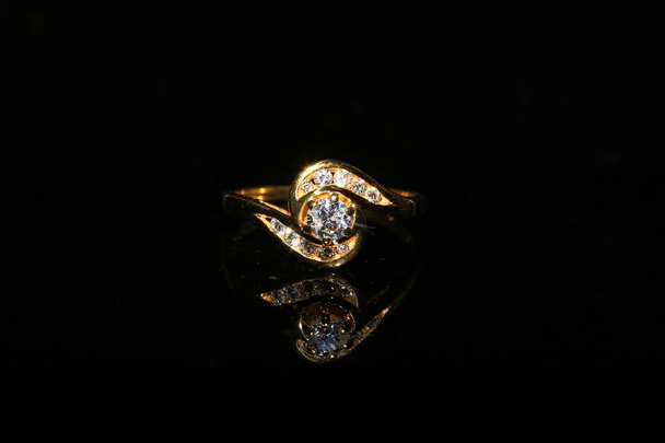 Бриллиантовое кольцо и драгоценный камень на черном фоне
 - Фото, изображение