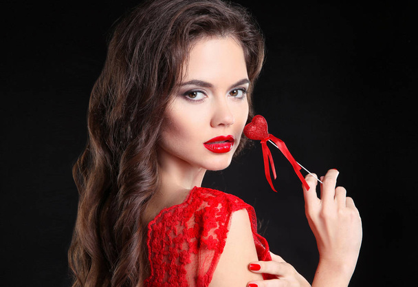 Red lips. Beautiful brunette girl portrait holding heart gift fo - Foto, afbeelding