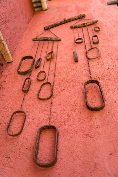 Set van oude metalen kettingen opknoping op een rode muur - Foto, afbeelding