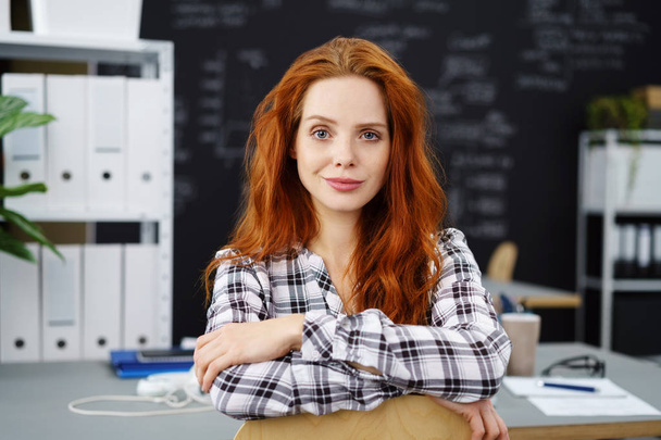 Grinning red head in flannel shirt in office - 写真・画像