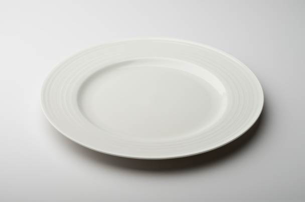 Άδειο στρογγυλό λευκό πιάτο με διακοσμημένο περιθώριο - Φωτογραφία, εικόνα