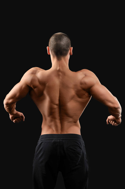 Gespierde fitness man op zwarte achtergrond - Foto, afbeelding