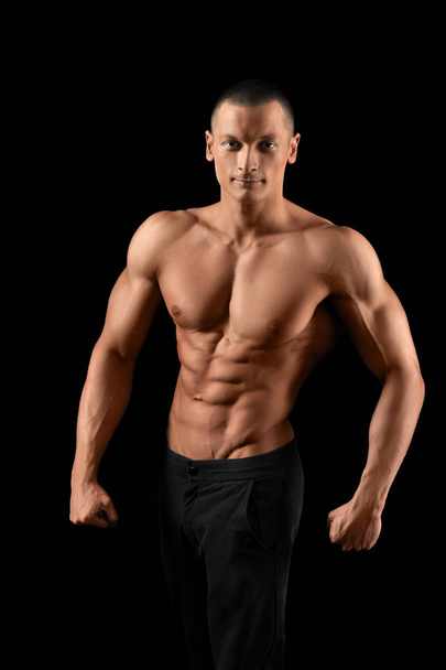 Svalová fitness muž na černém pozadí - Fotografie, Obrázek