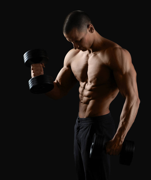 Male bodybuilder posing in studio - Фото, зображення