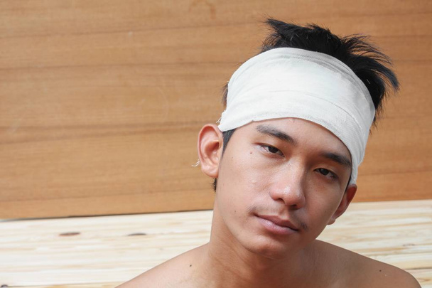 Młody mężczyzna z urazem głowy. przez medyczne bandaż  - Zdjęcie, obraz