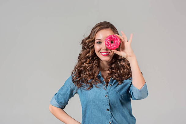 The smiling girl on gray studio background with round cake - Foto, imagen