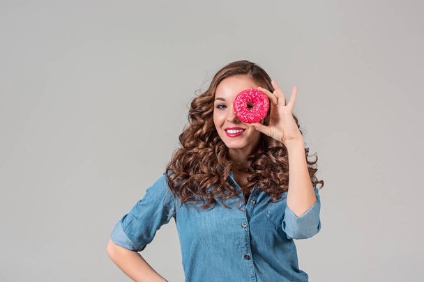 The smiling girl on gray studio background with round cake - 写真・画像