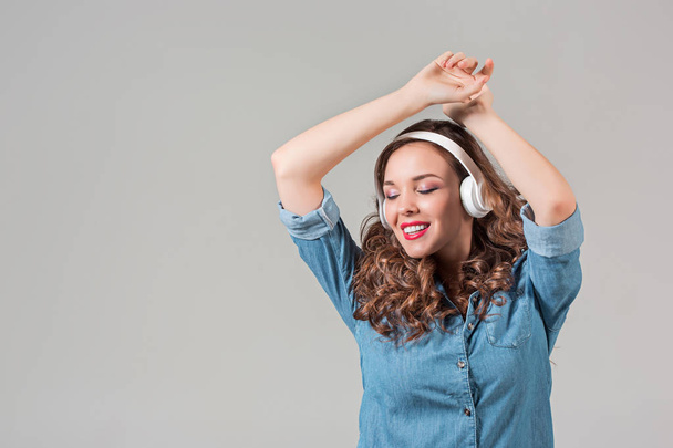 Happy young woman listening music with headphones. - Фото, изображение
