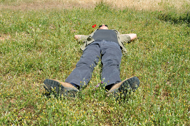 Człowiek leżący na trawie - Zdjęcie, obraz