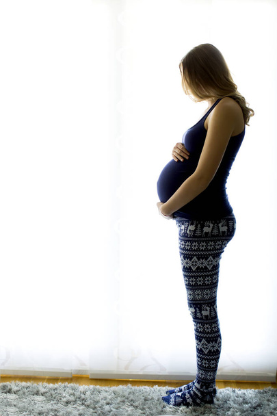 junge schwangere Frau im Schlafzimmer - Foto, Bild
