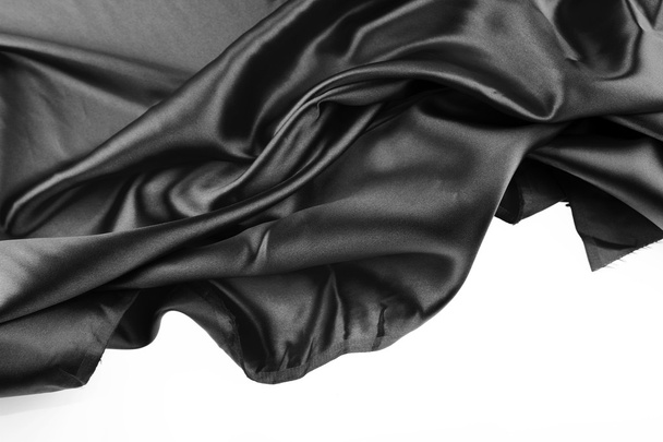 Closeup of folds in black silk fabric on white background - Photo, Image