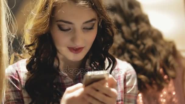 Woman looking at her smartphone indoor - Záběry, video
