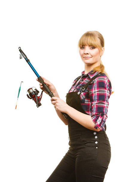 Similing woman wearing check shirt holding fishing rod - Фото, зображення